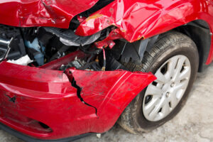 Damaged front bumper of red car